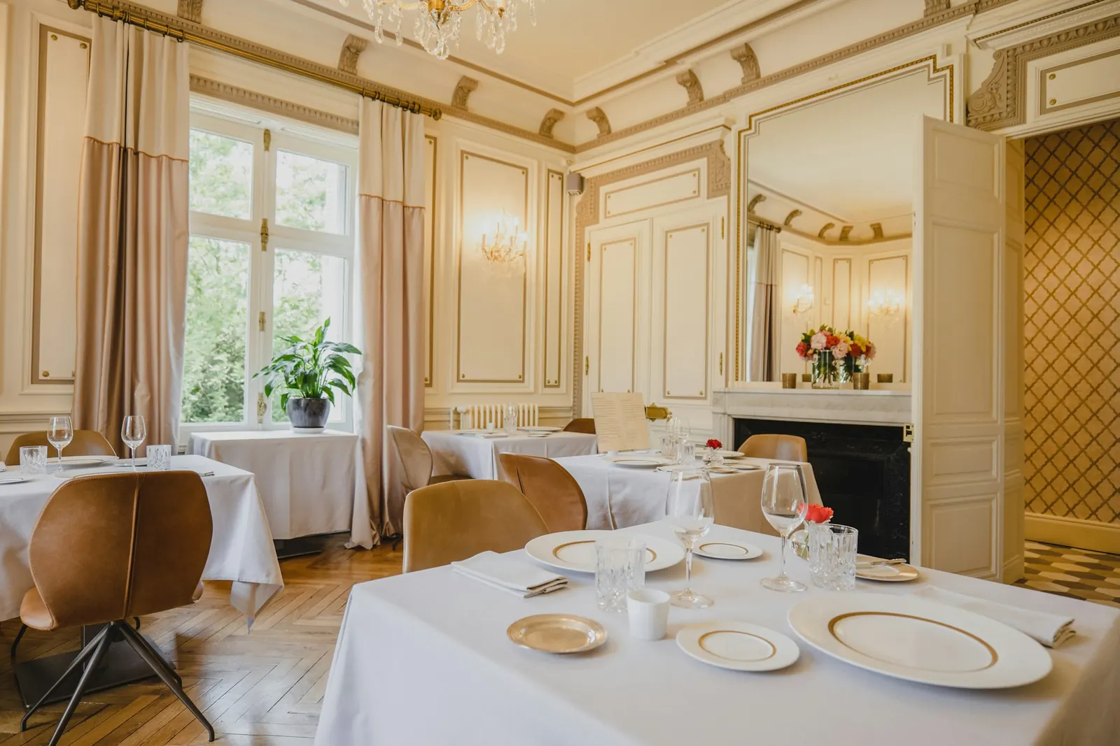 Elegant restaurant dining room with white tablecloths and gold-rimmed plates